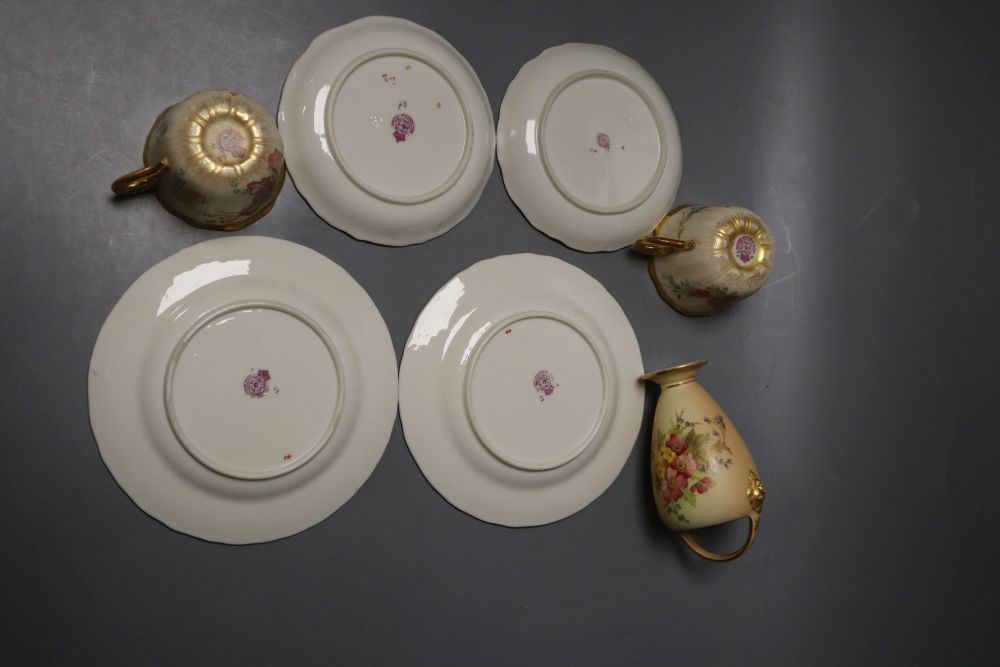 A Royal Worcester over-handled vase painted with flower on a blush ivory ground and two Royal Worcester cups, saucers and side plates